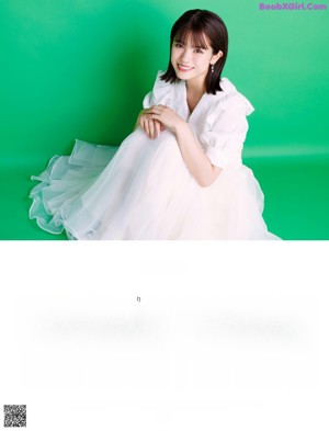 A woman in a white dress is jumping in the air.