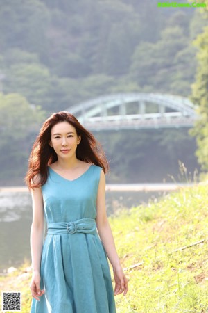 A woman in a white shirt is posing for a picture.