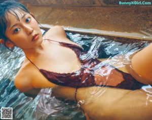 A woman in a purple dress laying on a bed.