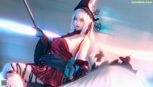 A woman dressed as a witch holding a wand.