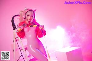 A woman in a pink outfit holding a gun.