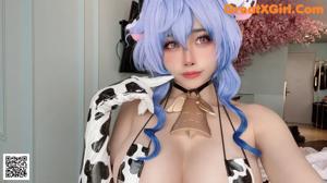 A woman with blue hair in a cow print bikini.