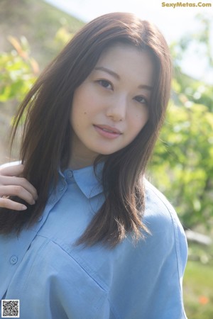 A woman in a blue and white bikini posing for a picture.