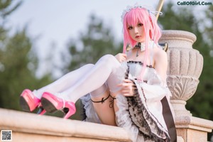 A woman in a pink and white dress holding a sword.