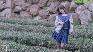 A woman in a blue shirt and black stockings posing for a picture.