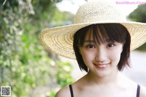 A woman in a yellow and white checkered dress posing for a picture.