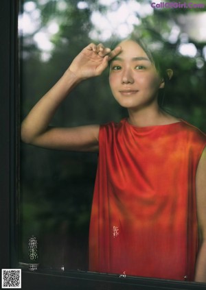 A woman sitting on a couch with her hand on her chin.