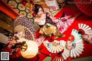 A woman in a kimono holding a red umbrella.