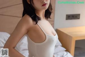 A naked asian woman wearing bunny ears posing for the camera.