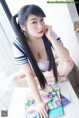 A woman in a black lingerie sitting on a window sill.