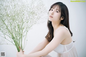 A woman laying on a bed with a bunch of flowers.