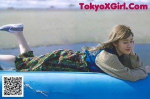 A woman in a colorful kimono standing on a beach.