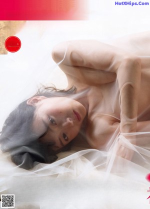 A naked woman sitting on a window sill next to a window.